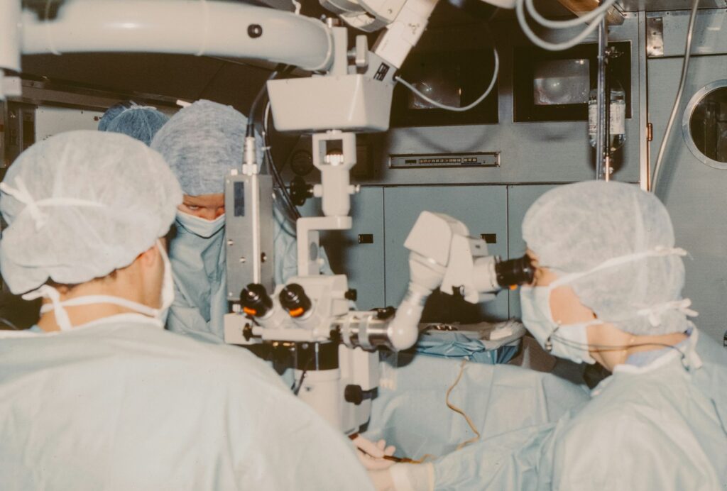 Surgeons performing corneal transplant surgery using an operating microscope in a clinical setting