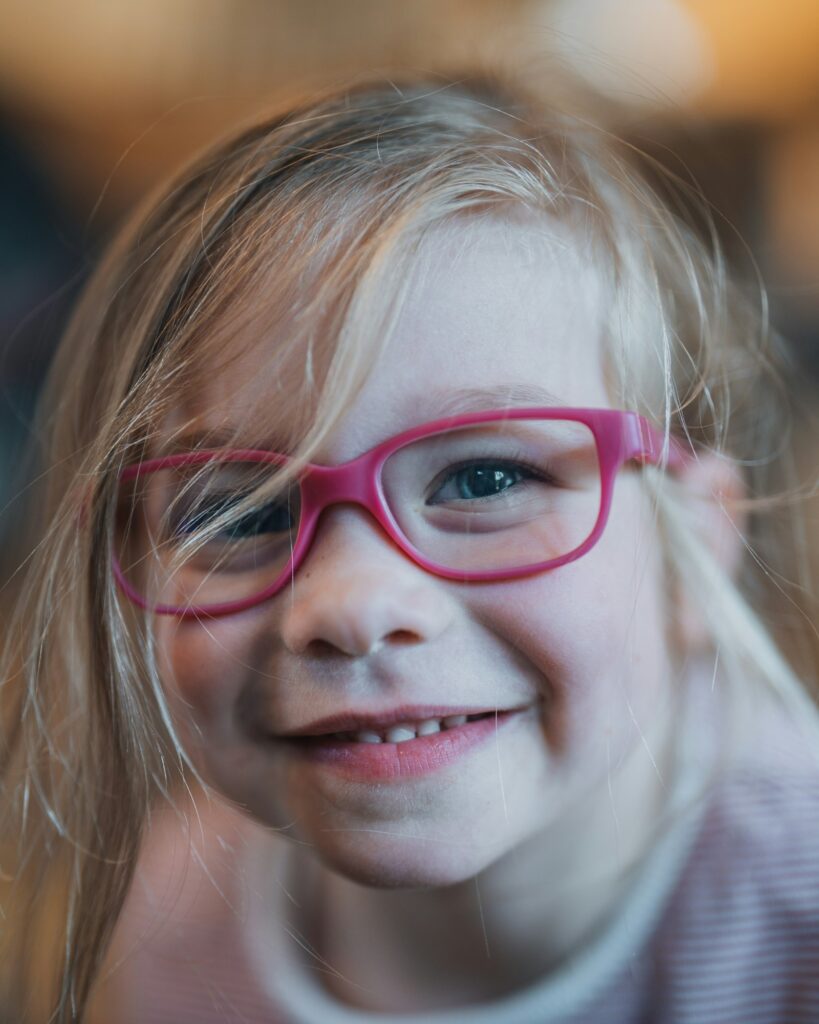Smiling child wearing glasses after a back-to-school eye exam