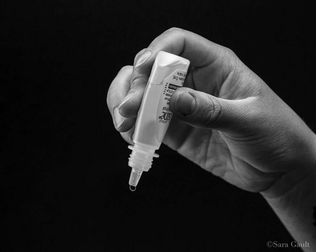 Person applying lubricating eye drops for dry eye relief