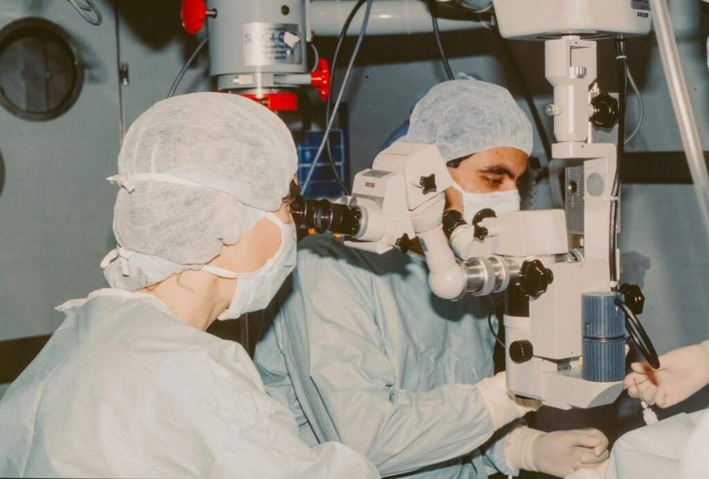 Surgeons performing PRK laser eye surgery using an operating microscope in a sterile clinical setting